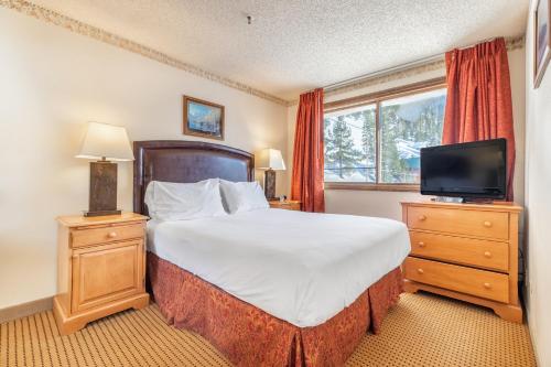 a bedroom with a large bed and a television at Heidelberg Inn & Resort in June Lake