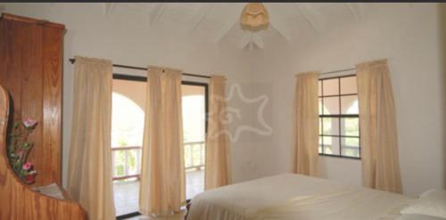 um quarto com uma cama e duas janelas em The View Villa em Port Elizabeth