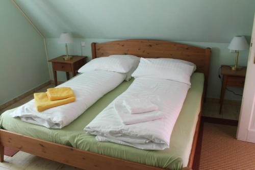 uma cama com lençóis brancos e toalhas em Altes Waschhaus Krakvitz em Putbus