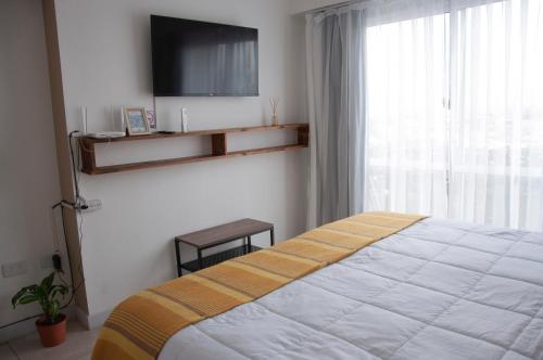 ein Schlafzimmer mit einem Bett und einem TV an der Wand in der Unterkunft Departamento los Poetas in Salta