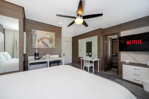 a bedroom with a large bed with a ceiling fan at Deco Boutique Hotel in Fort Lauderdale