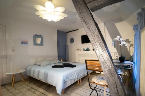 une chambre avec un lit blanc et une table dans l'établissement Les Cieux de la Cathédrale - Calme - Jardin - Wifi, à Troyes