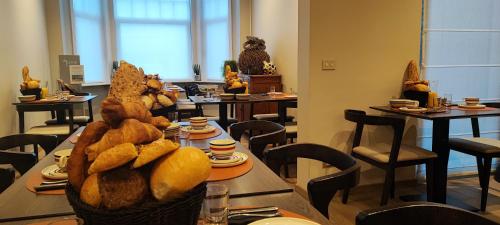 ein Restaurant mit Tischen und Stühlen und einem Korb mit Brot in der Unterkunft B&B Charles Cabour in De Panne