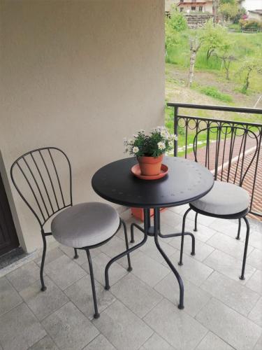 two chairs and a table with a plant on a patio at Tenuta Rella in Dronero