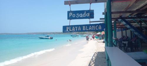 a beach with a sign that reads hawaiian blanket at Hostal Playa Blanca in Playa Blanca