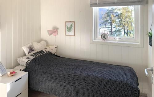 a bedroom with a black bed and a window at 5 Bedroom Gorgeous Home In Vikedal in Vikedal