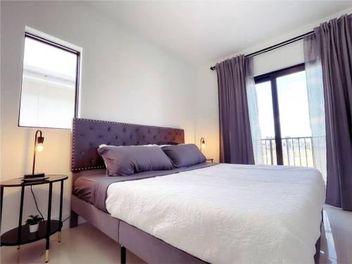 Un dormitorio con una cama grande y dos ventanas. en Casa Relax Total, en Florida City