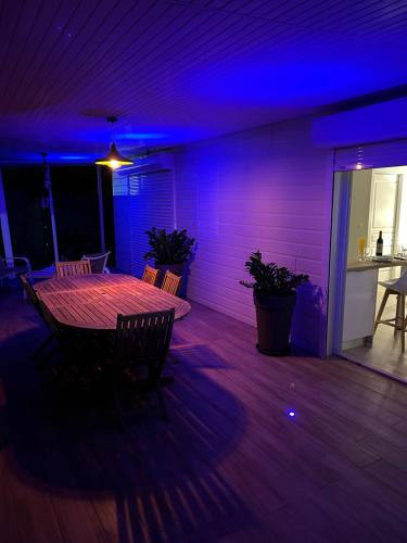 a dining room with a table and purple lights at Bungalow Beausejour in Le Moule