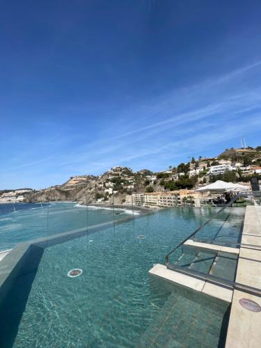 a swimming pool with a view of the ocean at ON ALETA ROOM designed for adults in Almuñécar