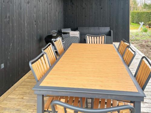 a wooden table and chairs on a patio at Seaside Bliss in Nysted - By Traum Ferienwohnungen in Nysted