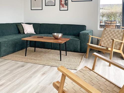 a living room with a green couch and a table at Seaside Bliss in Nysted - By Traum Ferienwohnungen in Nysted