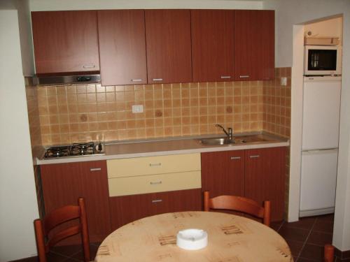 a small kitchen with a table and a sink at Apartment Nemarnik in Roč