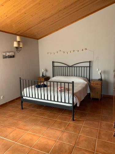 1 dormitorio con cama y techo de madera en CAL XECARMA en Tordera