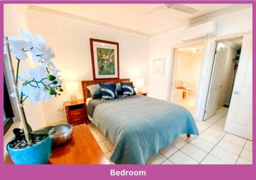 een slaapkamer met een bed met een blauwe sprei bij Magic On Melton in Townsville