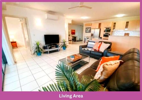a living room with a couch and a tv at Magic Ocean Views On Melton in Townsville