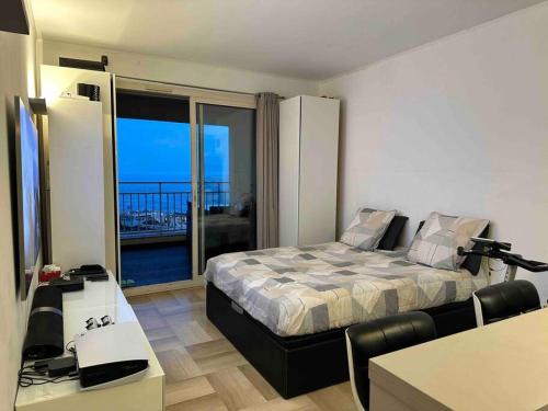 Studio à Monaco Fontvieille في مونت كارلو: غرفة نوم مع سرير وإطلالة على المحيط