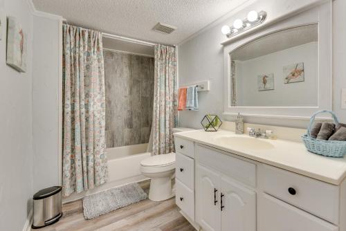 a bathroom with a sink and a toilet and a mirror at Rock Hill Cottage with Spacious Yard and Fire Pit! in Rock Hill