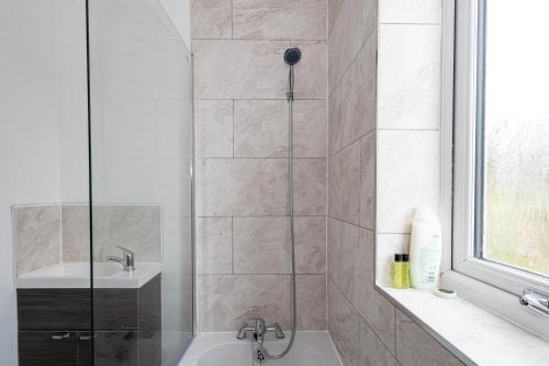 y baño con ducha, bañera y lavamanos. en M9 Guest House, en Mánchester