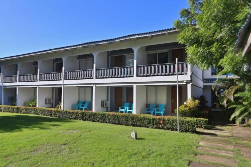 un edificio con sillas azules delante de él en Puerto Azul Hotel & Marina en Puntarenas