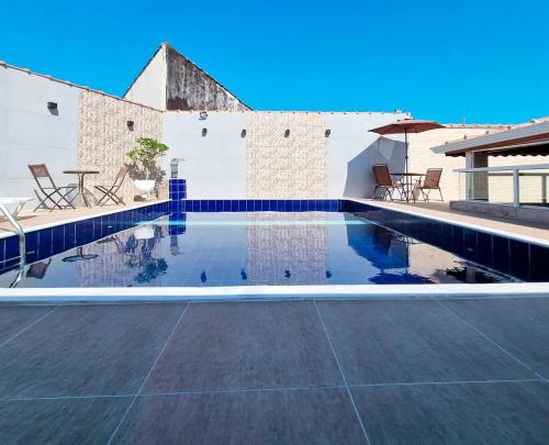 Una piscina con una mesa y sillas en un patio. en Casa com piscina e Wi Fi em Mongagua SP, en Praia Grande