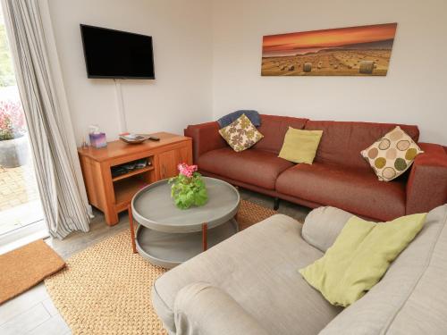 a living room with a couch and a table at The Coach House in Newport