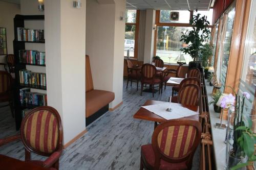a restaurant with a table and chairs and a book shelf at Zorn Hotel Duinlust in Noordwijk aan Zee