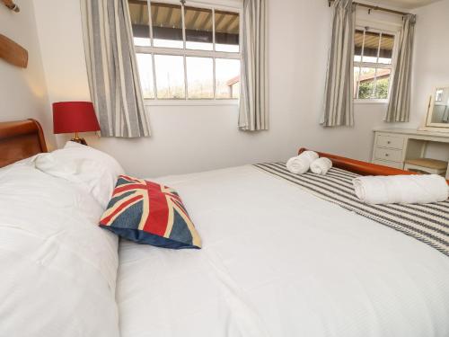 a bedroom with a white bed with two pillows on it at The Coach House in Newport