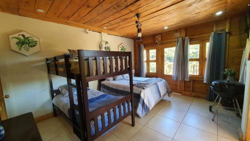 a bedroom with two bunk beds in a cabin at Casa Katok in Sonsonate