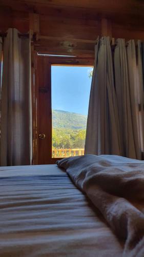 a bedroom with a bed and a window with a view at Casa Katok in Sonsonate