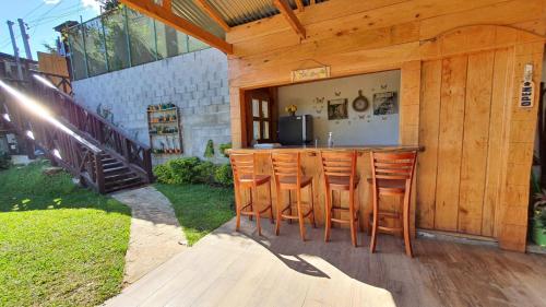 an outdoor bar with wooden stools in a backyard at Casa Katok in Sonsonate