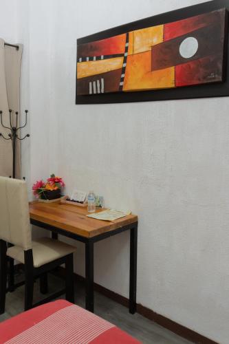 a dining room table with a painting on the wall at Hotel Makarios in Tuxtla Gutiérrez
