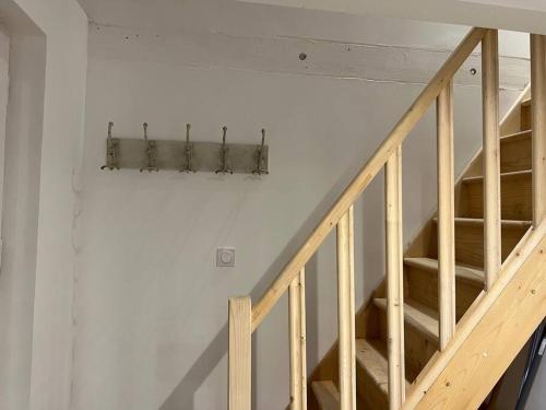 a wooden staircase in a room with a white wall at Le nid de Nuits in Nuits-Saint-Georges