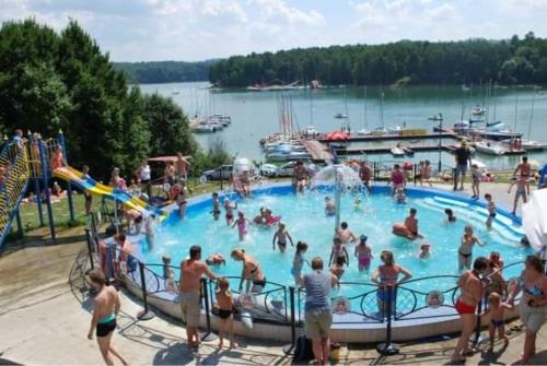 a group of people in a pool at a water park at Apartamenty Zatoka Relaksu Sauna i Balia in Polańczyk