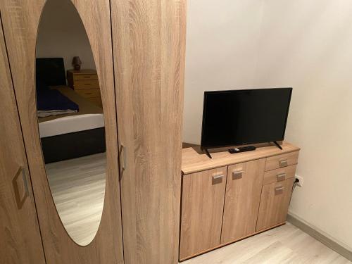 a room with a mirror and a tv on a dresser at 3 Zimmer Apartment in Bayreuth