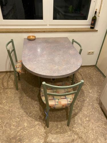 een tafel en twee stoelen met een tafel en een fles bij 3 Zimmer Apartment in Bayreuth