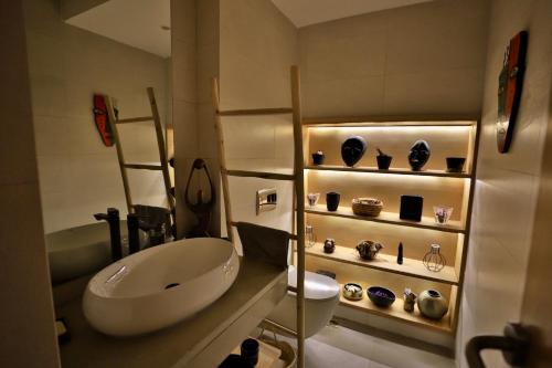 a bathroom with a sink and a shelf with vases at Moon house in Ville Nouvelle