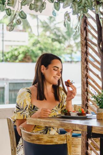 a woman sitting at a table with a plate of food at Ixchel Beach Hotel in Isla Mujeres
