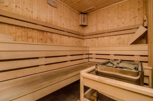 a wooden sauna with a tub in the middle at Apartament o2 ALLDAYHOLIDAY Mielno in Mielno