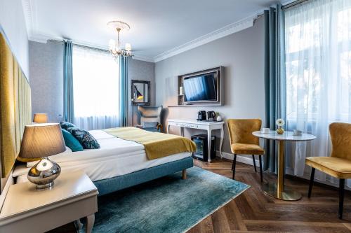 Habitación de hotel con cama, escritorio y sillas en Villa Antonina, en Sopot