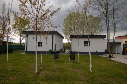 a group of trees in a yard next to a building at Vikendica na Drini - Drinska priča in Loznica