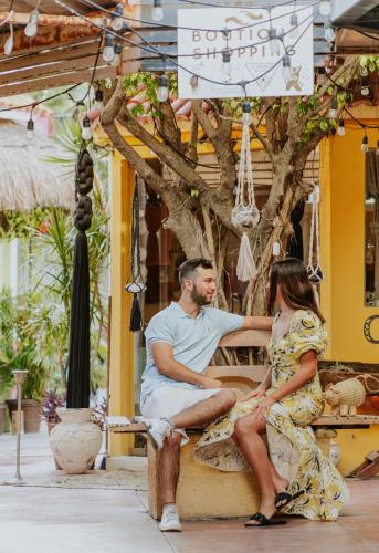 a man and a woman sitting on a bench at Ixchel Beach Hotel in Isla Mujeres
