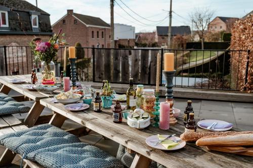 a wooden table with food and drinks on a patio at SintPieter17 Lo-Ghis vakantiewoning in Voeren