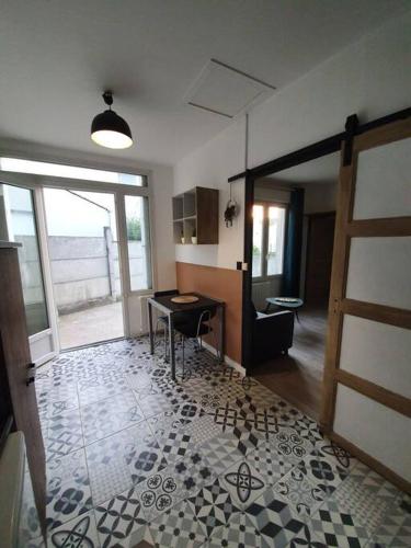 een kamer met een keuken met een tafel en een deur bij Maisonnette T1 avec jardin in Saint-Laurent-sur-Sèvre