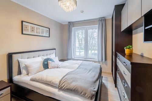 een slaapkamer met een groot wit bed en een raam bij Polanki Paradise in Kołobrzeg