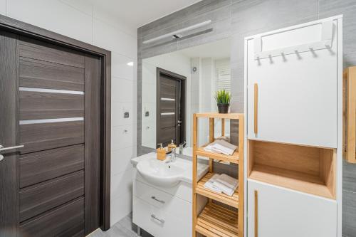 een badkamer met een wastafel, een toilet en een spiegel bij Polanki Paradise in Kołobrzeg