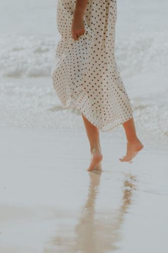 a woman is walking on the beach at Ixchel Beach Hotel in Isla Mujeres