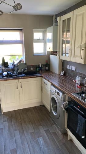 a kitchen with a sink and a washing machine at Luxury In in Parkside