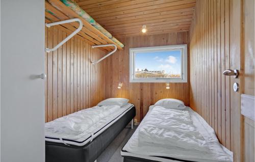 een kamer met 2 bedden in een houten kamer bij Gorgeous Home In Brenderup Fyn With Kitchen in Vedelshave
