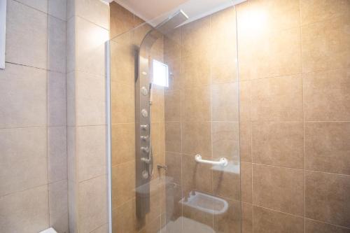 uma casa de banho com um chuveiro e uma porta de vidro em Departamento vista al rio 2 dormitorios, dos baños. Amplio y moderno em Posadas