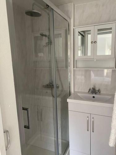 a bathroom with a shower and a sink at Centrally located flat with parking in Tetbury